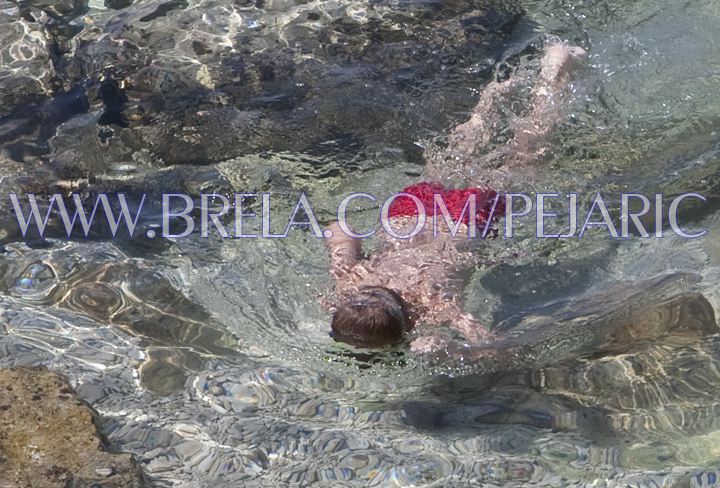 Brela beach - child is diving in crystal clar sea